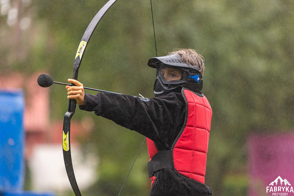 dziecko gra w archery tag podczas wycieczki szkolnej