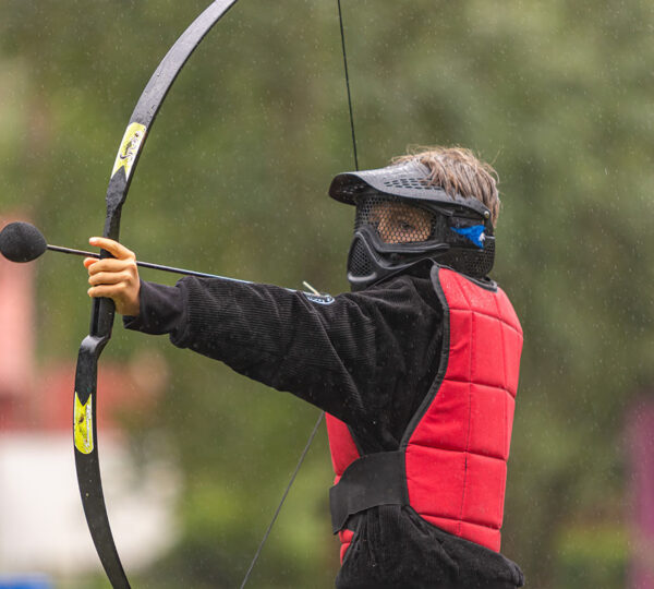 dziecko gra w archery tag podczas wycieczki szkolnej