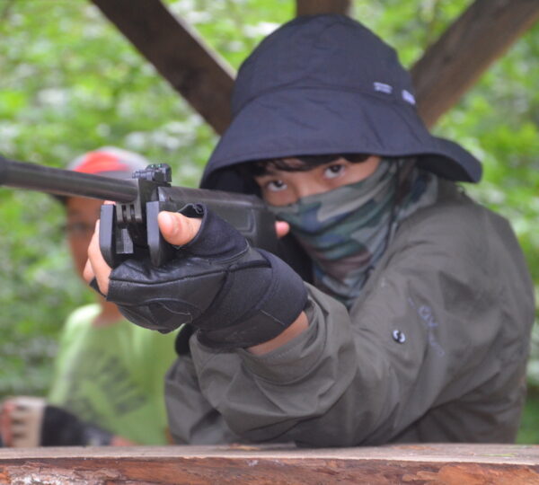 chłopiec strzela z wiatrówki na obozie survival