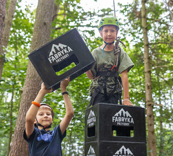 szczęśliwe dzieci na wyciczece szkolnej budują wieżę ze skrzynek