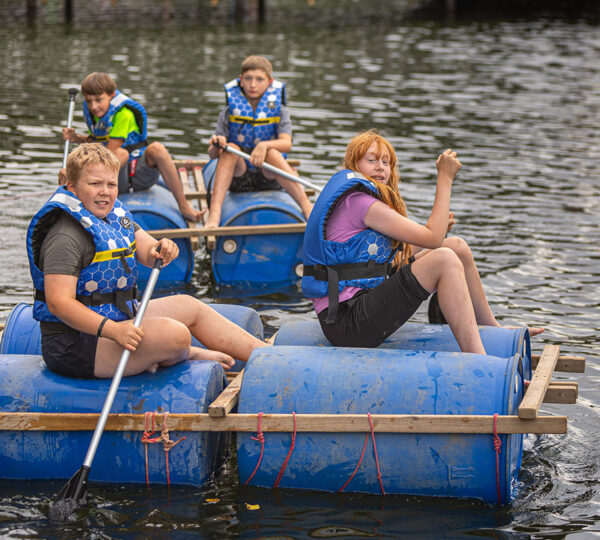 grupa dzieci pływa na tratwie